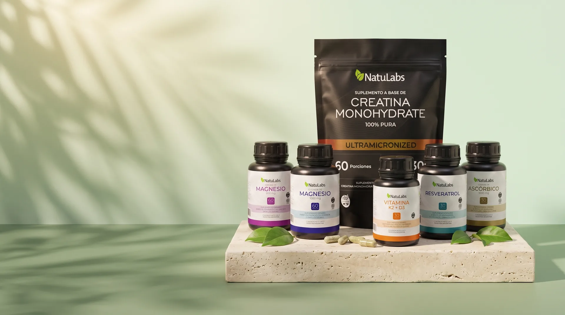 Los seis productos NatuLabs sobre un bloque de travertino: creatina monohidrato al fondo y, adelante, citrato de magnesio, glicinato de magnesio, vitamina K2 + D3, resveratrol y vitamina C.